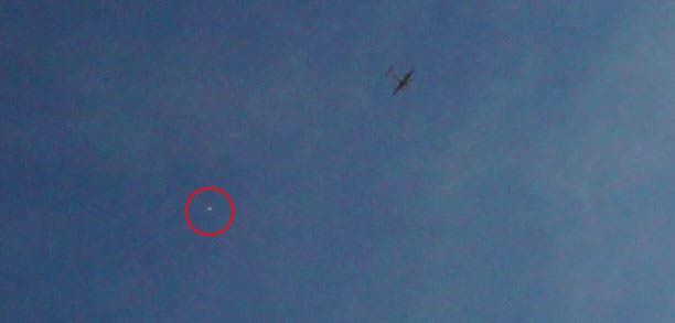 Airplane with strange object near it